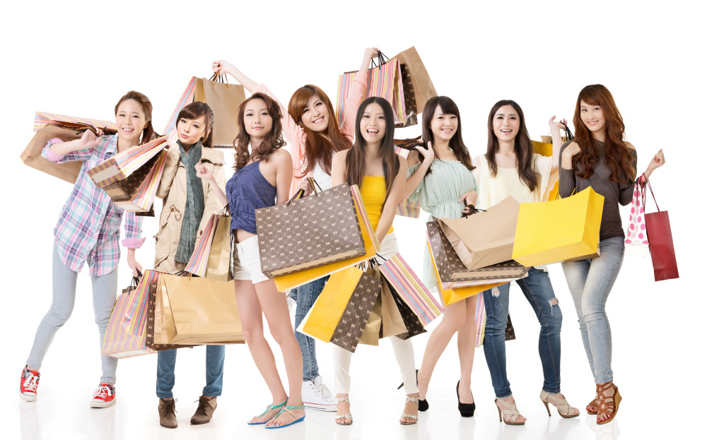 Happy Asian shopping girls on white background.